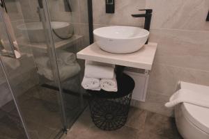 a bathroom with a sink and a glass shower at Pannolio Beach Boutique Apartment in Eisenstadt