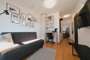 a living room with a couch and a desk at Pannolio Beach Boutique Apartment in Eisenstadt
