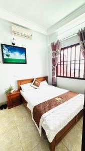 a bedroom with a bed and a tv on the wall at Trung Liên Hotel in Đảo Cô Tô