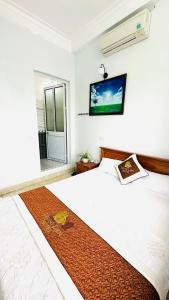a bedroom with a bed and a tv on the wall at Trung Liên Hotel in Đảo Cô Tô