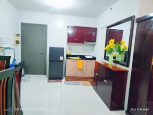 a kitchen with a refrigerator and a counter with flowers on it at Sugarland Urban Nook in Bacolod