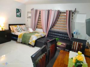 a bedroom with a bed and a window with curtains at Sugarland Urban Nook in Bacolod +1 photo