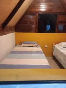 a bedroom with two beds in a attic at Lucmabamba Cabaña de los Duendes in Sahuayacu