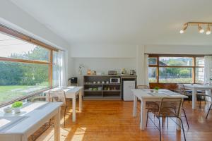 a room with tables and chairs and a kitchen at Hostería Carelhue in San Carlos de Bariloche