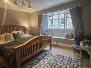 a bedroom with a large bed and a window at Cotswold Gardens Bed and Breakfast in Stow on the Wold