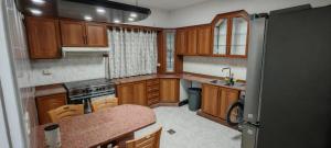a small kitchen with wooden cabinets and a counter top at cozy home in Jerash