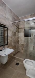 a bathroom with a toilet and a sink and a shower at cozy home in Jerash +7 photos