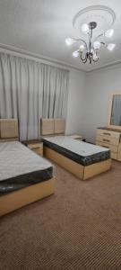 a bedroom with two beds and a chandelier at cozy home in Jerash