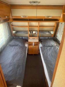 a small room with two beds and a desk at Camping Alex in Cadenazzo