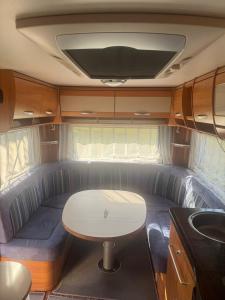 a couch in the back of an rv with a table at Camping Alex in Cadenazzo