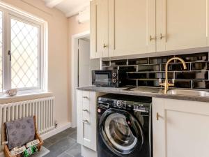 a kitchen with a washing machine and a microwave at 2 Bed in Westerham oc-88626 in Westerham +19 photos