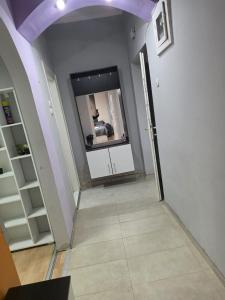 a hallway with a mirror and a person in a room at MBM Apartman in Bitola
