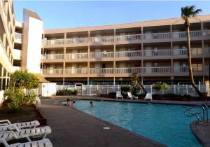 a hotel with a swimming pool in front of a building at Spectacular Beach View! in Corpus Christi