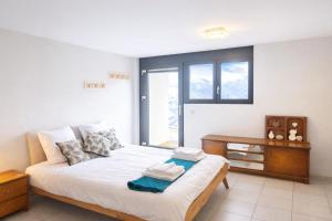 a bedroom with a bed and a desk and a window at Maison D'Hortense chalet le Chamois in Hérémence