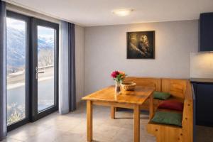 a living room with a table and a kitchen at Maison D'Hortense chalet le Chamois in Hérémence