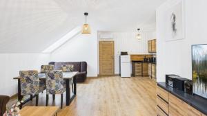 a living room with a table and chairs and a kitchen at Dębówka - apartament rodzinny in Wilcze