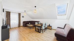 a living room with a couch and a table at Dębówka - apartament rodzinny in Wilcze
