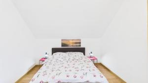 a bed in a white room with two tables at Dębówka - apartament rodzinny in Wilcze
