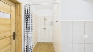 a bathroom with a shower with white tiles at Dębówka - apartament rodzinny in Wilcze