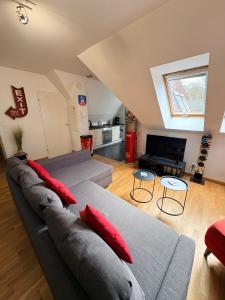 a living room with two gray couches with red pillows at Amiens LOFT in Amiens