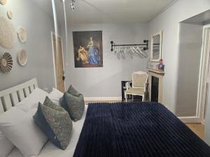 a bedroom with a bed and a painting on the wall at Cotswold Gardens Bed and Breakfast in Stow on the Wold