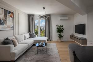 a living room with a white couch and a tv at Iman Apartments in Zagreb
