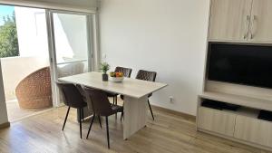 a dining room with a table with chairs and a television at Casa Luca in Carvoeiro