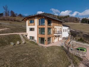 a house on top of a grassy hill with at Nest Love, Bedollo Ospitar in Bedollo