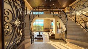 a staircase in a house with a wrought iron gate at Villa Seaview, Private Oceanfront Villa, Heated Pool & Whale Watching Views, Knysna Heads in Knysna