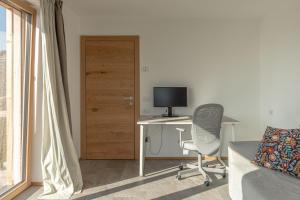 a room with a desk and a computer and a door at Nest Love, Bedollo Ospitar in Bedollo