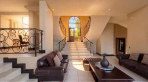 a living room with a couch and a staircase at Villa Seaview, Private Oceanfront Villa, Heated Pool & Whale Watching Views, Knysna Heads in Knysna +27 photos