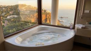 a bath tub with a view of the ocean at Villa Seaview, Private Oceanfront Villa, Heated Pool & Whale Watching Views, Knysna Heads in Knysna
