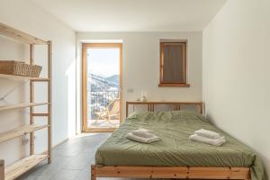 a bedroom with a bed and a large window at Nest Love, Bedollo Ospitar in Bedollo