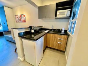 a small kitchen with a counter and a microwave at Loft near Santa Casa - Apt 604 in Porto Alegre