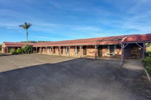 a large brick building with a parking lot at Fernvale Hotel Motel in Fernvale
