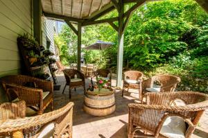 a patio with wicker chairs and a table and a barrel at La beuillotte in Bar-sur-Seine