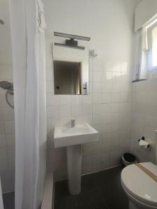a white bathroom with a sink and a toilet at Romeu in Quarteira +57 photos