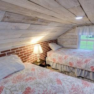 a bedroom with two beds and a brick wall at Nita's Nest in Foley