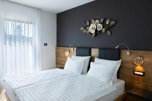 a bedroom with a bed and a clock on the wall at Rooms Gašper 1 in Postojna