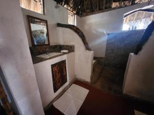 a bathroom with a sink and a mirror at Lemara Eco Camp in Kisaki