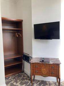 a room with a desk and a tv on a wall at Kurhaus Bad Doberan in Bad Doberan
