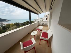 a balcony with chairs and tables and a view of the ocean at Suites Prestige in Peschici