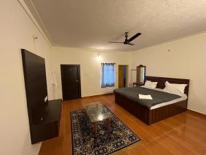 a bedroom with a bed and a ceiling fan at Aroha Farm Stay in Yelagiri