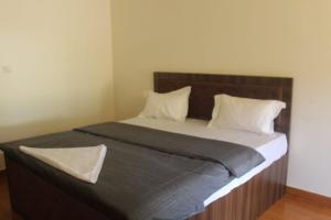 a large bed with a wooden headboard in a bedroom at Aroha Farm Stay in Yelagiri