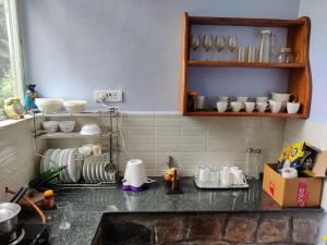 a kitchen counter with a sink and some dishes at Aroha Farm Stay in Yelagiri