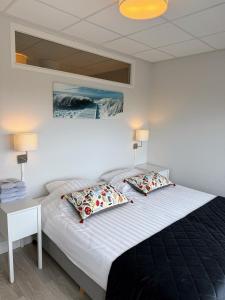 a bedroom with a large bed with two pillows at Residence Le Mistral in Noordwijk aan Zee