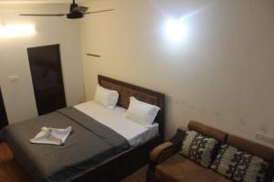 a bedroom with a bed and a couch at Aroha Farm Stay in Yelagiri