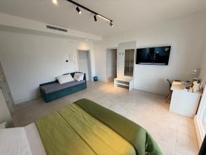 a large white room with a bed and a couch at Suites Prestige in Peschici