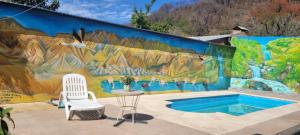 a mural on a wall next to a table and chairs at ROMA in Reyes