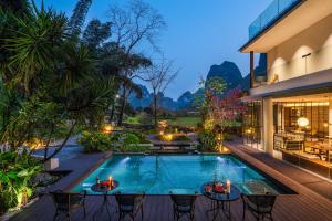 an outdoor patio with a swimming pool and a house at Hidden Valley Hotel-- New Hotel,A Hidden Gem,Serene Sanctuary,Exclusive Location,Swimming Pool & Cycling Route,Attraction Tickets Serivce in advance,Affordable Luxury,Best Karst Mount View in Yangshuo in Yangshuo